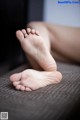 A close up of a person's bare feet on a couch.