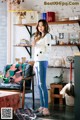 A woman standing in a living room next to a couch.