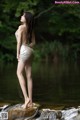 A woman standing on a rock in the water.