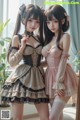 two asian women in maid outfits posing for a picture