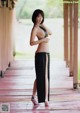 A woman in a black bikini top and black skirt posing for a picture.