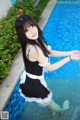 A woman in a maid outfit standing in a pool.