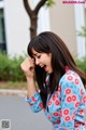 A woman in a blue and red floral shirt laughing.