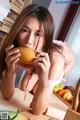 A woman in a pink bikini eating a mango.