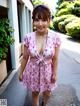 A woman in a pink dress is walking down the street.