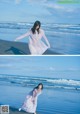 A woman in a long dress standing on the beach.