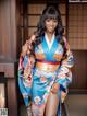 A woman in a blue and orange kimono posing for a picture.