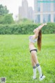 A woman in a bikini standing in a field of grass.