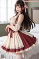 A woman in a maid outfit posing on a bed.