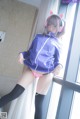 A woman in a purple jacket and pink panties with headphones on.
